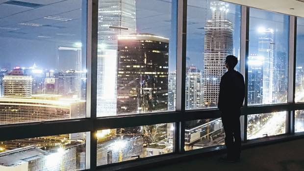 Ein Mann blickt auf die abendlich erleuchteten Wolkenkratzer in Peking. Wie die Hauptstadt haben sich alle größeren Städte Chinas in nur wenigen Jahren zu glitzernden modernen Metropolen entwickelt.